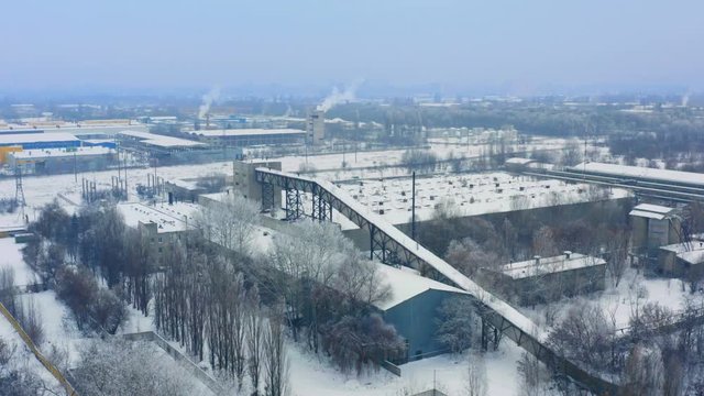 Aerial view of a building materials plant in industrial zone on a winter snowy day