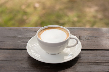 Coffee espresso on wood table nature background in garden,warm tone