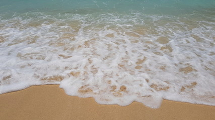 Sea water covers the sandy beach. Three colors on the background yellow, white, light blue. 
