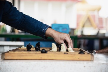 Local Thai people play old traditional Thai chess in public area - slow life style local people with chess board game concept