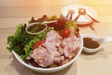 Salads bacon in a white bowl on table and empty space for text.