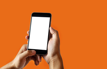 Hand holding white mobile phone with blank white screen  Orange background.