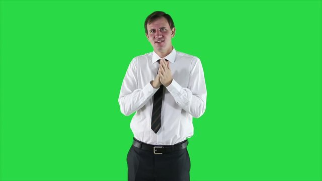Portrait of young businessman in white shirt and tie against a green screen.