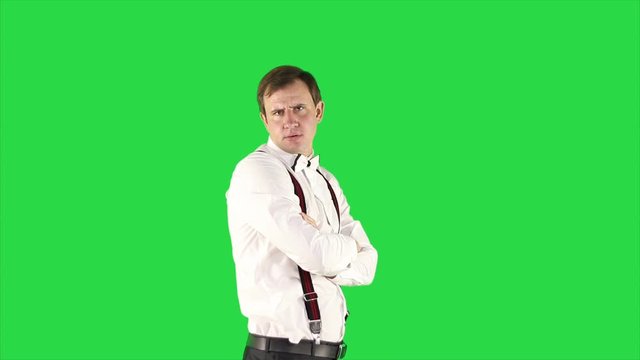 Portrait of young man in white shirt and tie on green background. 