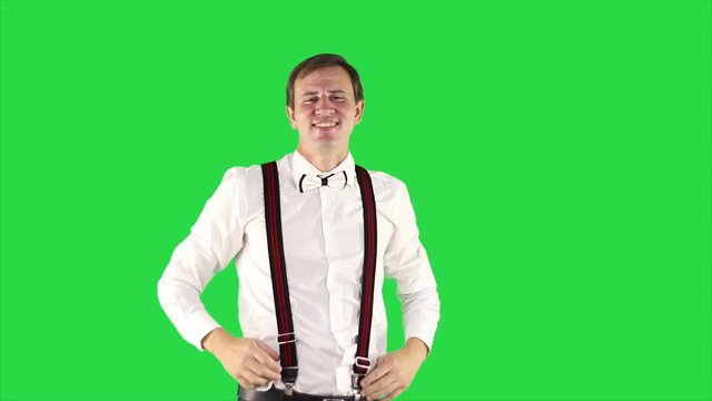 Portrait of modern young businessman. Successful businessman in white shirt making thumbs up on green background. 