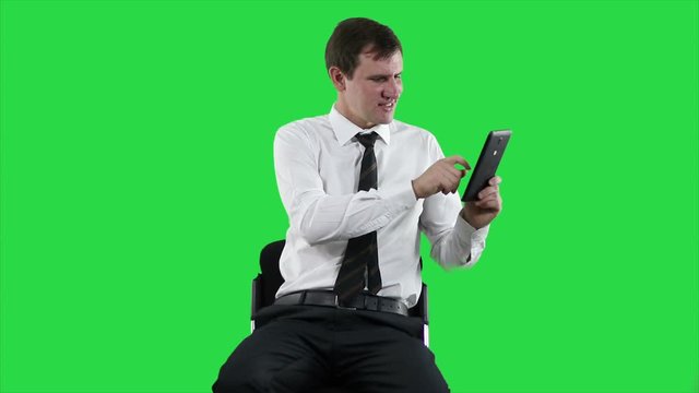 Businessman with digital tablet. Online video chat on tablet on green screen.