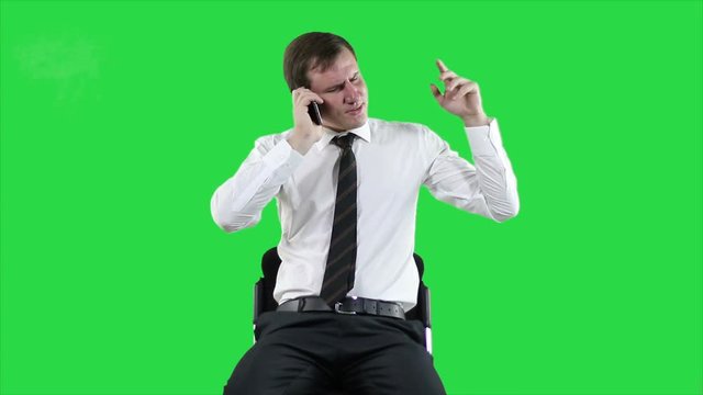 Businessman using smartphone. Cheerful entrepreneur speaking on mobile phone on green background. Funny talk on the phone. Positive relaxing businessman