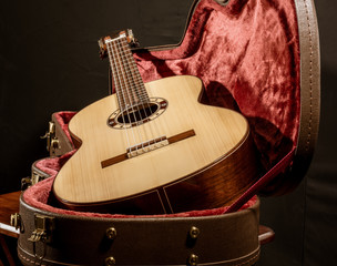 Acoutic guitar sits in red velvet lined case