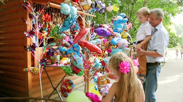 Kids and grandfather shopping for toys. Grandfather is buying toys his grandchildren. Kids are in a toy shop.