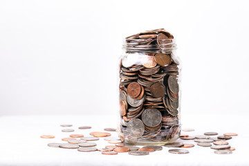 Money spilling over jar on a white background, saving money 