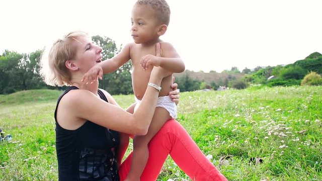Young mother and her two years old little son for a walk. Happy multiracial family. Carefree, fun lifestyle.