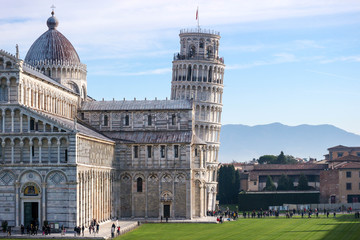 Fototapeta na wymiar Leaning tower of Pisa, symbol of Italy, and Pisa cathedral, with Tuscany mountains on the background