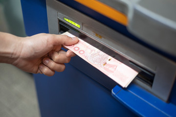 Woman hand withdrawing money from bank ATM machine.
