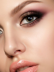 Closeup portrait of young beautiful woman with evening make up. Pink and gold multicolored smokey eyes. Luxury skincare and modern fashion makeup concept. Studio shot. Extreme closeup, partial face