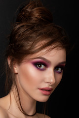 Fototapeta premium Closeup portrait of young beautiful woman with bright pink smokey eyes. Fashion makeup. Studio shot. Modern bright summer make up