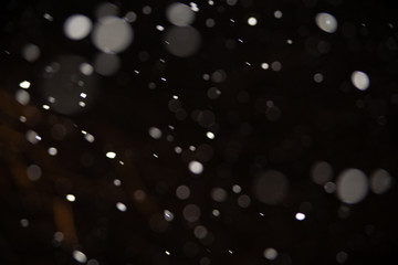 Background of falling snowflakes in the light of a lantern.