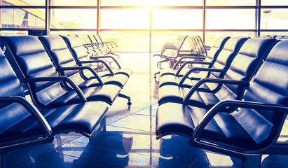 Seats in airport waiting room in sunlight.