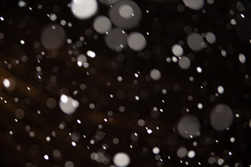 Background of falling snowflakes in the light of a lantern.