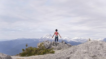 Aerial female climber celebrating success on peak Canada