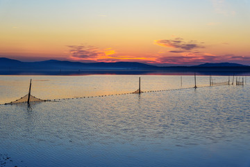 View of sunrise in lagoon Orbetello on peninsula Argentario. Italy