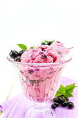 Ice cream with black currant in two glasses on board