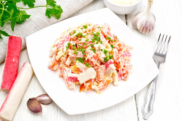 Salad of surimi and tomatoes with mayonnaise on board