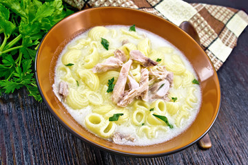 Soup creamy of chicken and pasta in plate on dark board