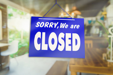 Sorry we are closed sign hang on door of business shop.