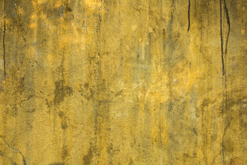 old dirty yellow wall with scratches and black spots. rough surface texture