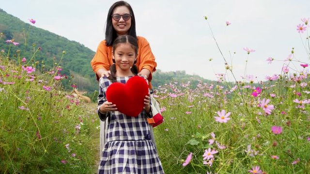 Slow motion mother and daughter  happy with heart in garden, Valentine concept