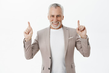 Old businessman inviting model to talk upstairs in restaurant. Portrait of charming and elegant...