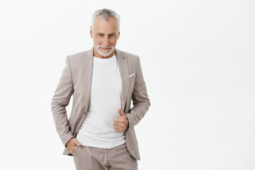 Portrait of stylish handsome and charismatic old male macho bachelor in formal suit holding hand in...