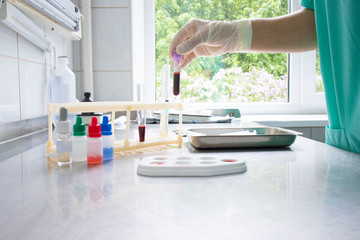 doctor determines the blood group in the treatment room on the medical table