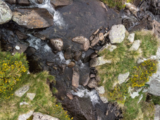 Aerial drone view landscape of river flowing down waterfall and over rocks in Snowdonia