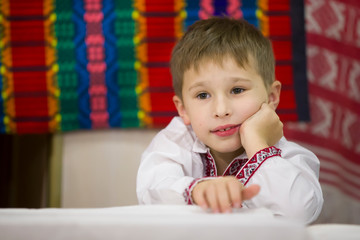 Naklejka premium Portrait of a small Belarusian or Ukrainian boy in embroidery.The boy in Slavic clothes