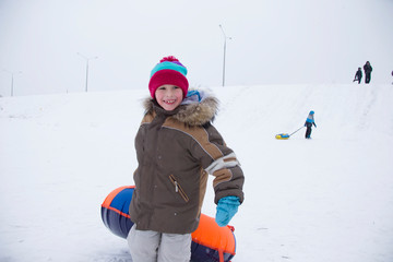 Sledding.Happy child on vacation. Winter fun and games.Little boy enjoying a sleigh ride.Children play outdoors in snow. Kids sled in the Alps mountains in winter