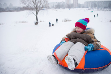 Sledding.Happy child on vacation. Winter fun and games.Little boy enjoying a sleigh ride.Children play outdoors in snow. Kids sled in the Alps mountains in winter