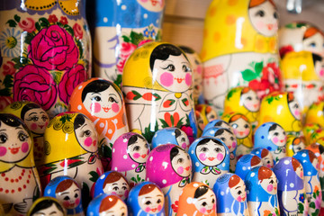 Fototapeta na wymiar Dolls, Matryoshka Doll, in Gift Shop Shelf. Colorful Set of Various Wooden Stacking Women Figure Dolls in Traditional Old Russian Clothes.