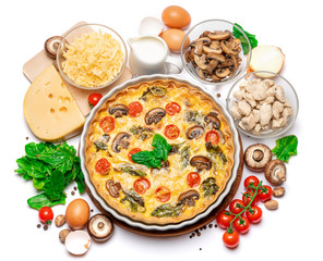 Baked homemade quiche pie in ceramic baking form, eggs and cream