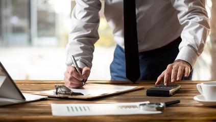 Man Working in Office and Analyzing Some Statistical Calculation Reports