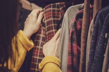 Young woman choosing clothes on a rack in a showroom