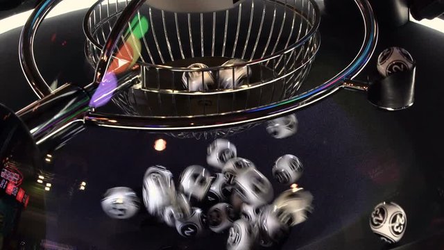 Black and white lottery balls in a rotating bingo machine. 4k