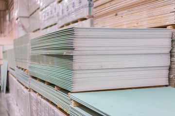 Gypsum plasterboard in the pack. The stack of gypsum board preparing for construction. Pallet with plasterboard in the building store. Construction Materials. Drywall warehouse. - obrazy, fototapety, plakaty