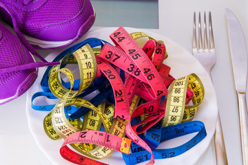 scales, sport shoes and colored measuring tape, concept of diet and health