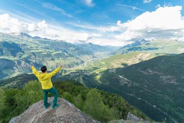 Escursionista in cima la montagna con le braccia alzate 