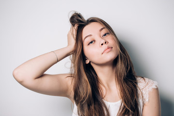 Fototapeta premium Beautiful portrait of young brunette woman with long hair on white background