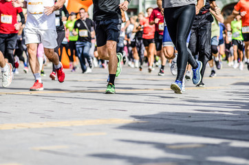 Group of runners running city marathon.