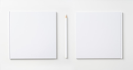 Top view of white notebook, page, pencil