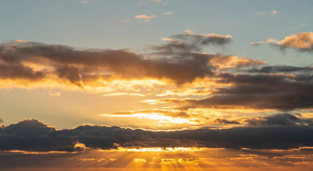 Beautiful colorful vibrant golden hour sunset skyscape with cloud formation and setting sun