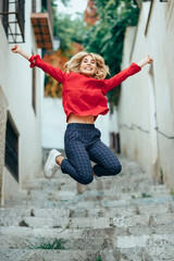 Happy young blond woman standing on beautiful steps in the street.